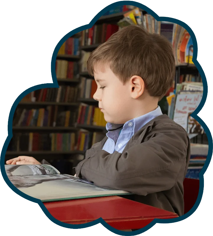 Menino a ler um livro numa biblioteca